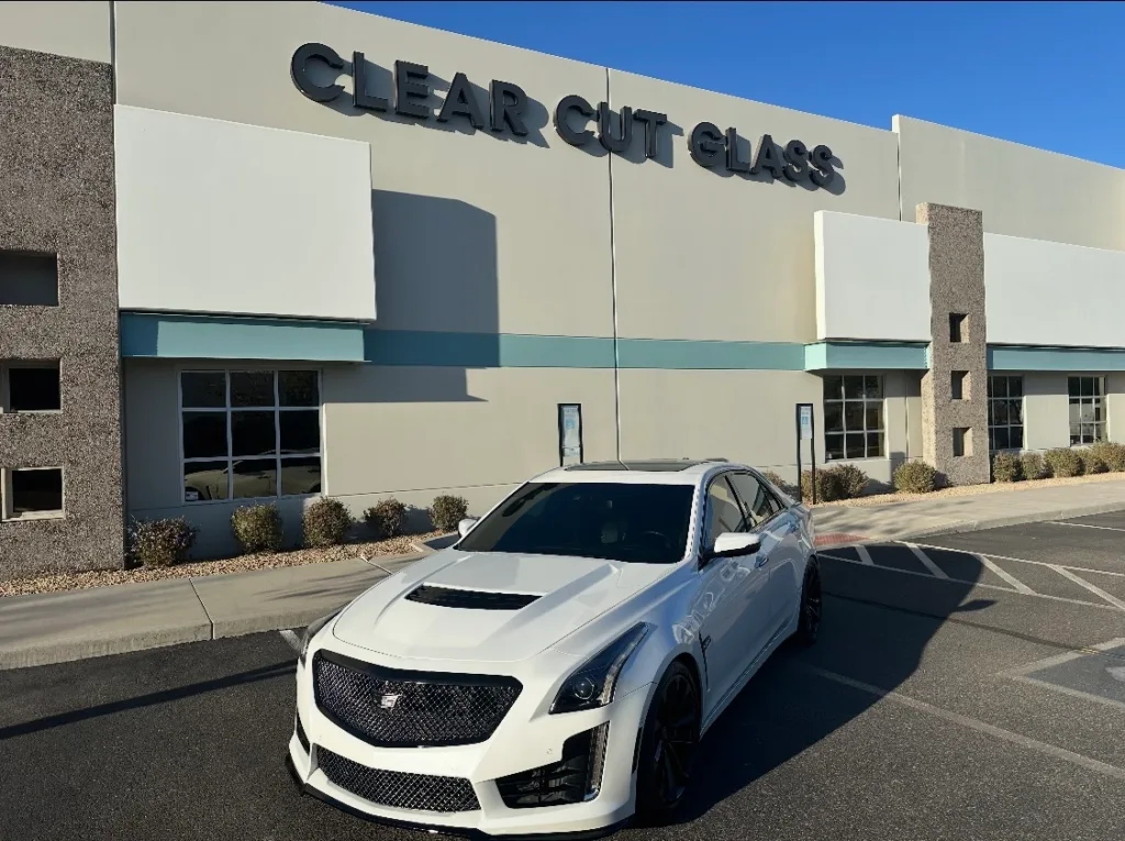 Cadillac CTS-V Window Tint at Clear Cut Glass and Tint Glendale AZ White Cadillac CTS-V with dark window tint parked in front of the Clear Cut Glass and Tint building in Glendale Arizona, representing professional auto tint and auto glass services.