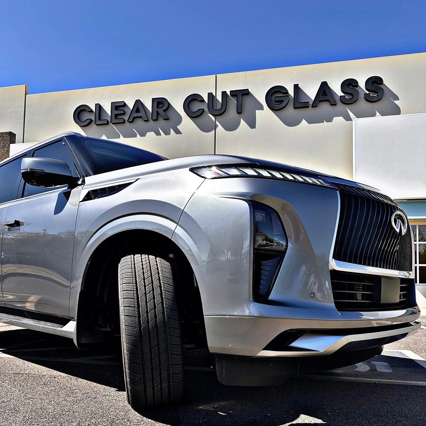Infiniti QX80 parked in front of Clear Cut Glass in Glendale, AZ, showcasing premium paint protection film services