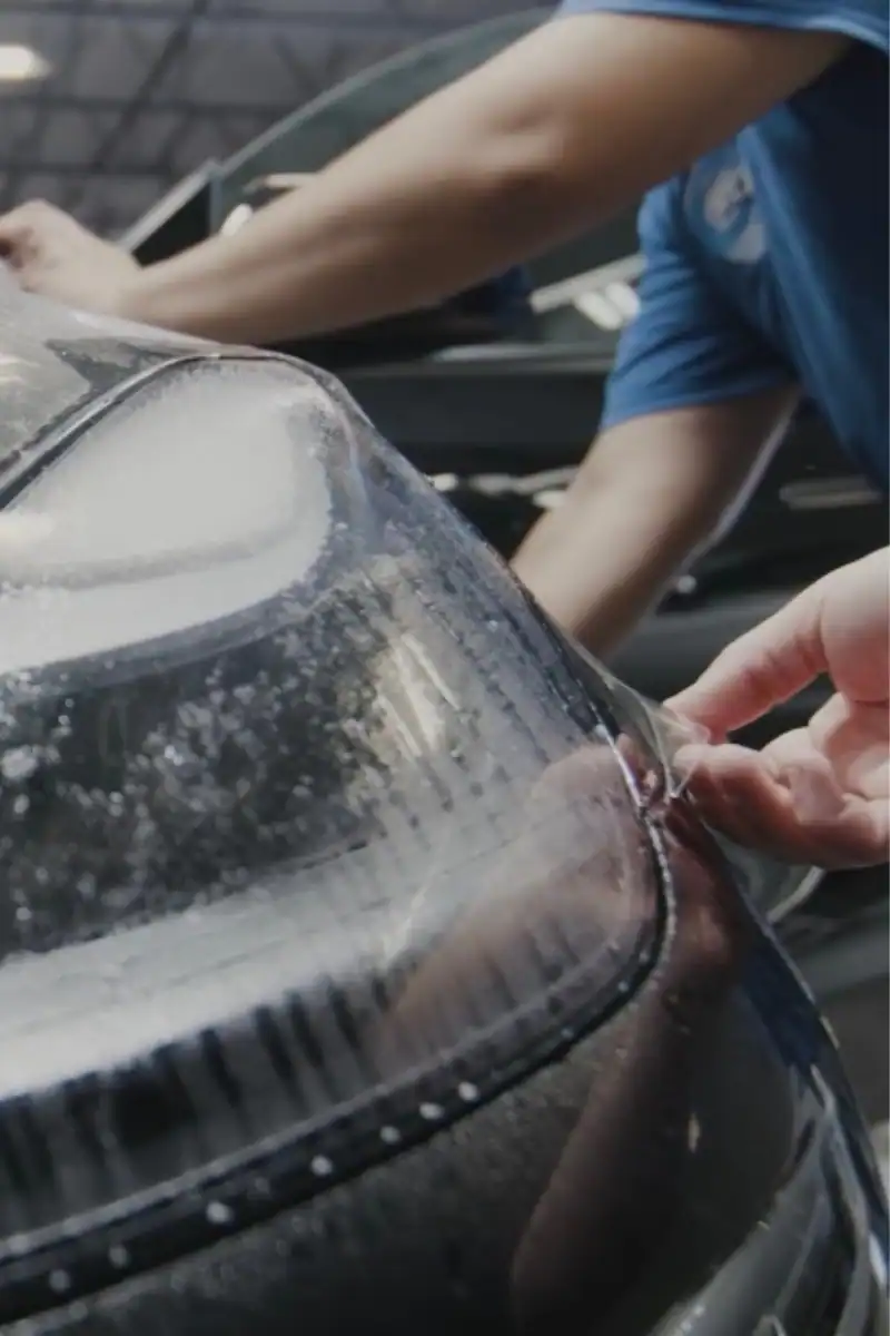 Technician installing paint protection film on a vehicle at Clear Cut Glass and Tint in Glendale Arizona, showing the detailed PPF application process.