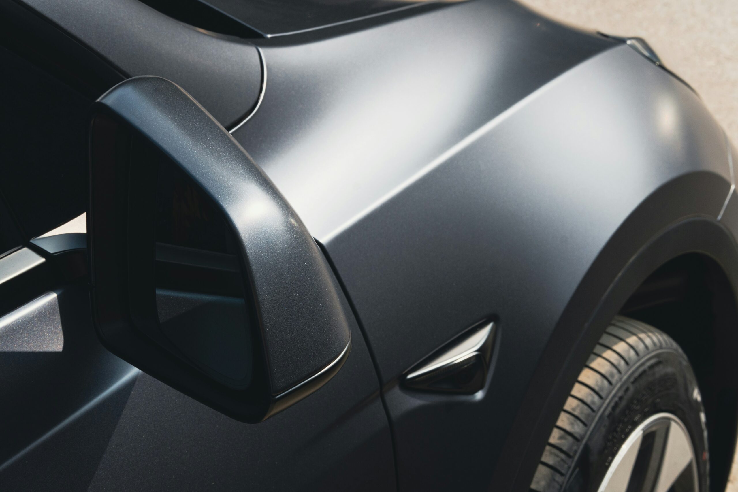 Close-up of matte black vehicle with paint protection film showing smooth finish and protected panel near side mirror in Glendale Arizona