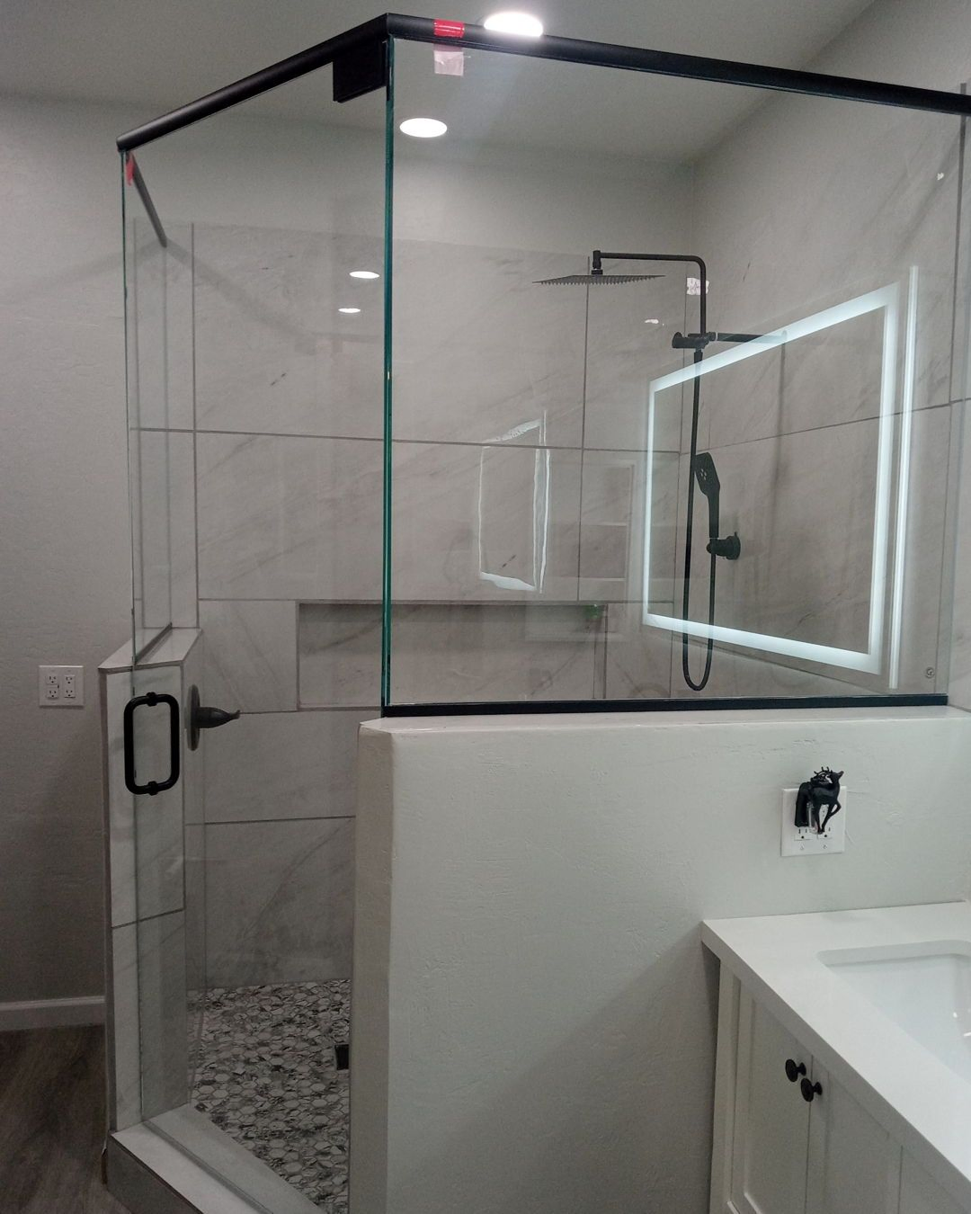 Corner Frameless Glass Shower with Black Hardware | Clear Cut Glass and Tint Corner frameless glass shower with matte black hardware and custom tile, installed in a modern Arizona bathroom by Clear Cut Glass and Tint