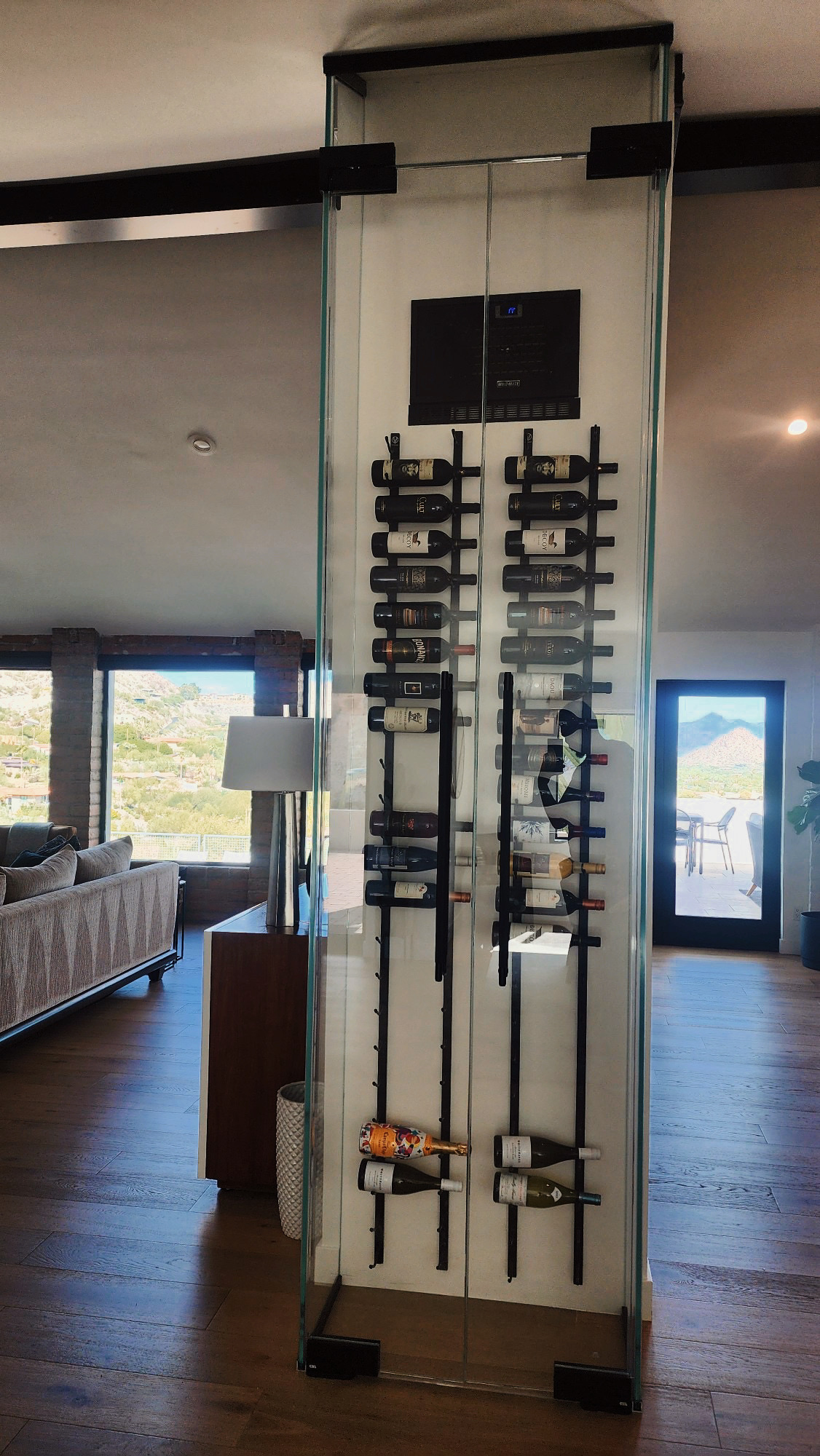 Custom Glass Wine Wall Display by Clear Cut Glass and Tint Floor-to-ceiling custom glass wine wall with mounted wine racks in a modern Arizona home, installed by Clear Cut Glass and Tint