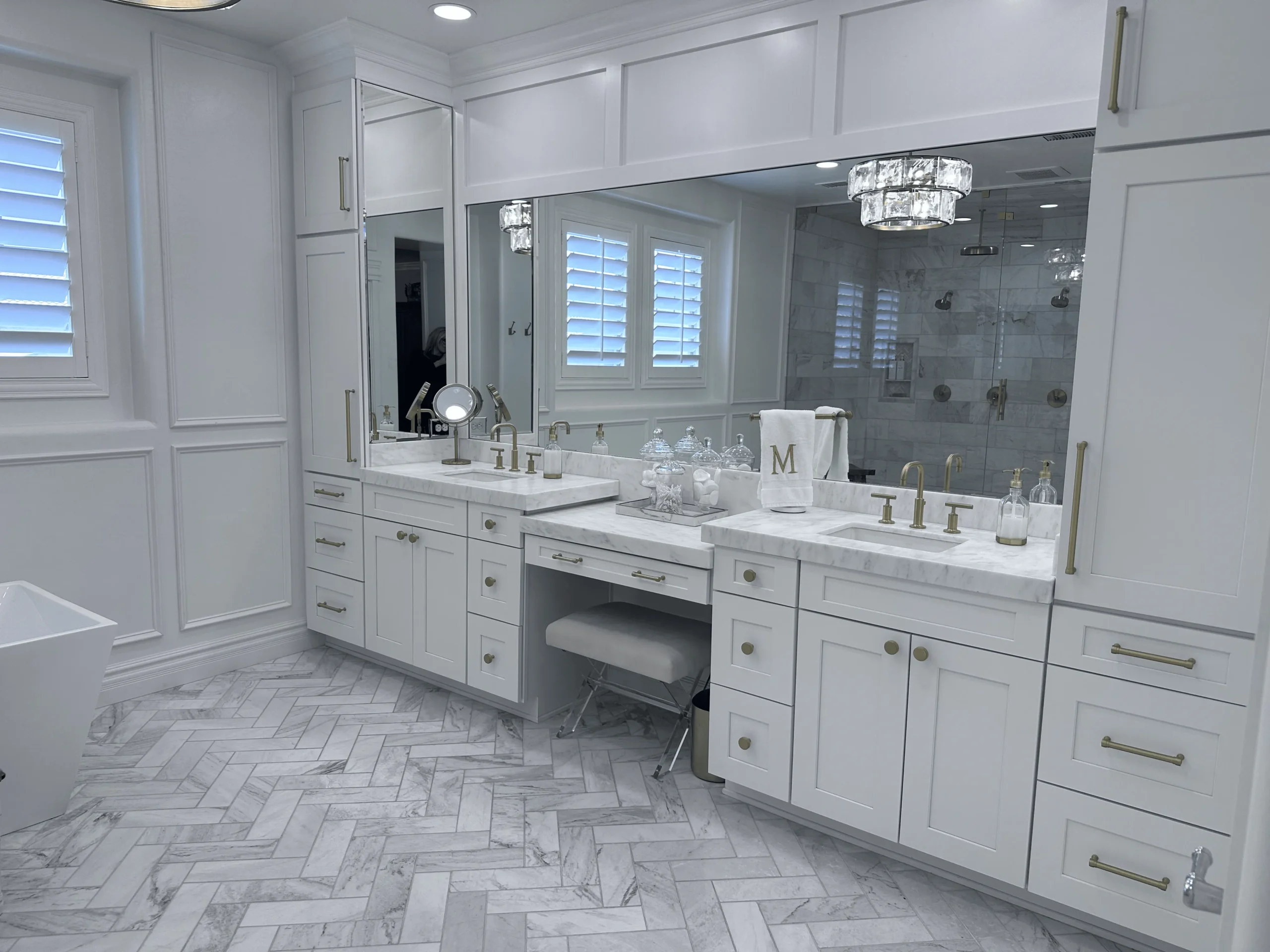 Luxury bathroom with custom vanity mirrors, white cabinetry, marble countertops, and brass fixtures, installed by Clear Cut Glass and Tint in Arizona