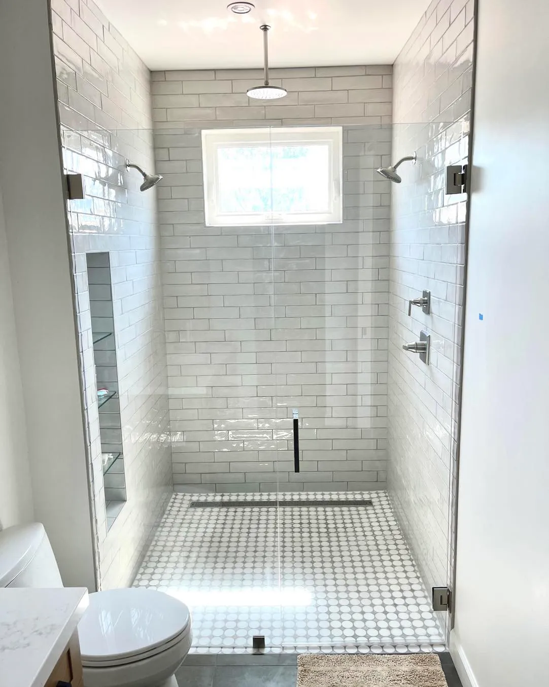 Frameless Walk-In Shower Installation | Clear Cut Glass and Tint Bright bathroom with frameless walk-in glass shower, white subway tile walls, and mosaic tile floor installed by Clear Cut Glass and Tint in Arizona