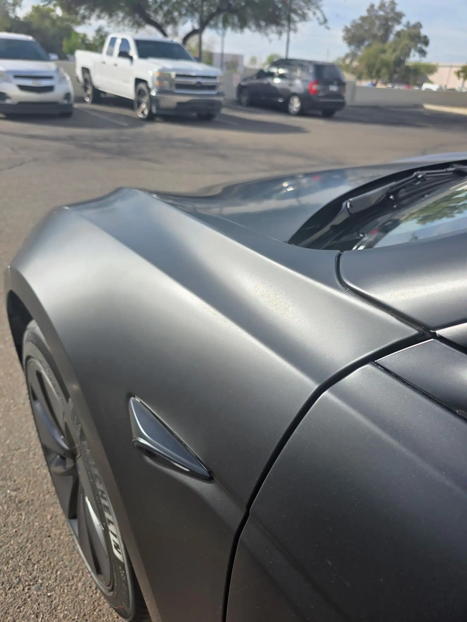 Close-up of matte black vehicle with paint protection film showing smooth finish and protected panel near side mirror in West Valley Phoenix, Glendale Arizona