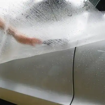 Low-quality paint protection film from Temu being applied to a car showing poor clarity, moisture trapping, and installation issues
