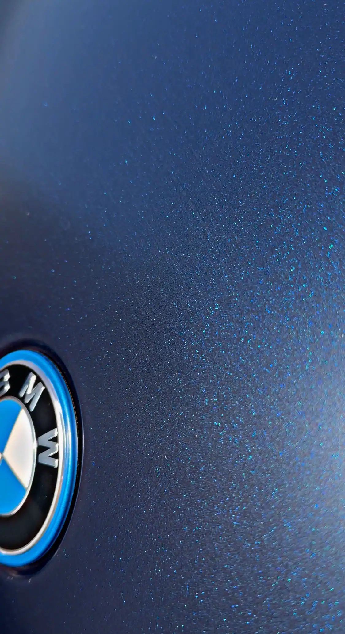 Close-up of metallic flake on matte BMW X5 showing clear paint protection film with no distortion or haze