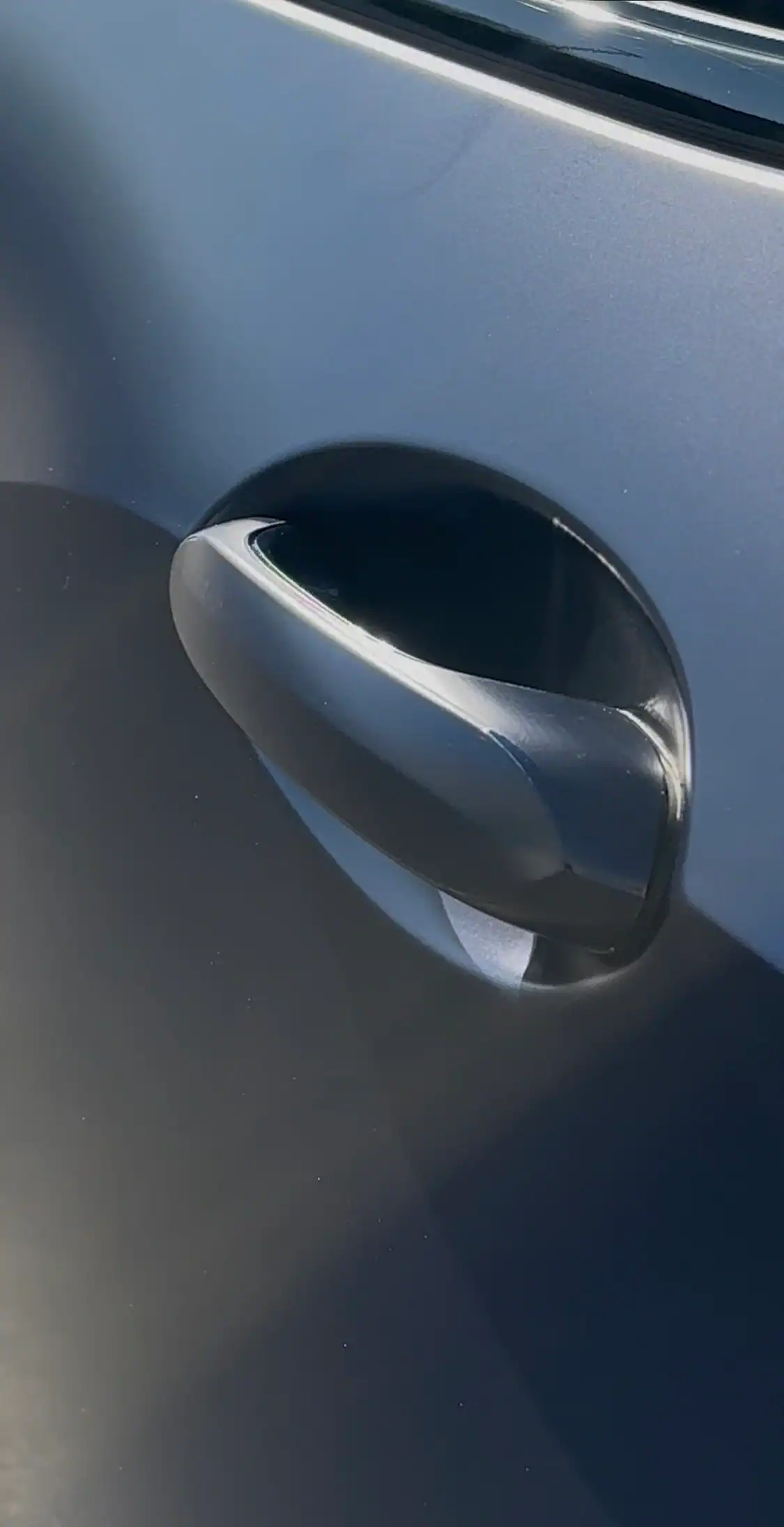 BMW X5 door handle with paint protection film installed showing clean edges around handle cup with no lifting or visible seams