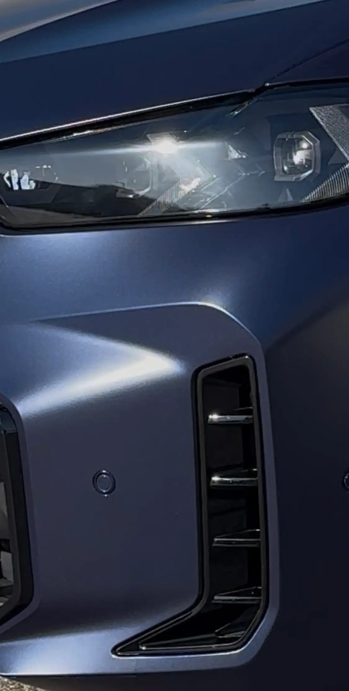 BMW X5 front headlight and bumper showing clean PPF edge wrapping around sensor and vent with no lifting or bubbles