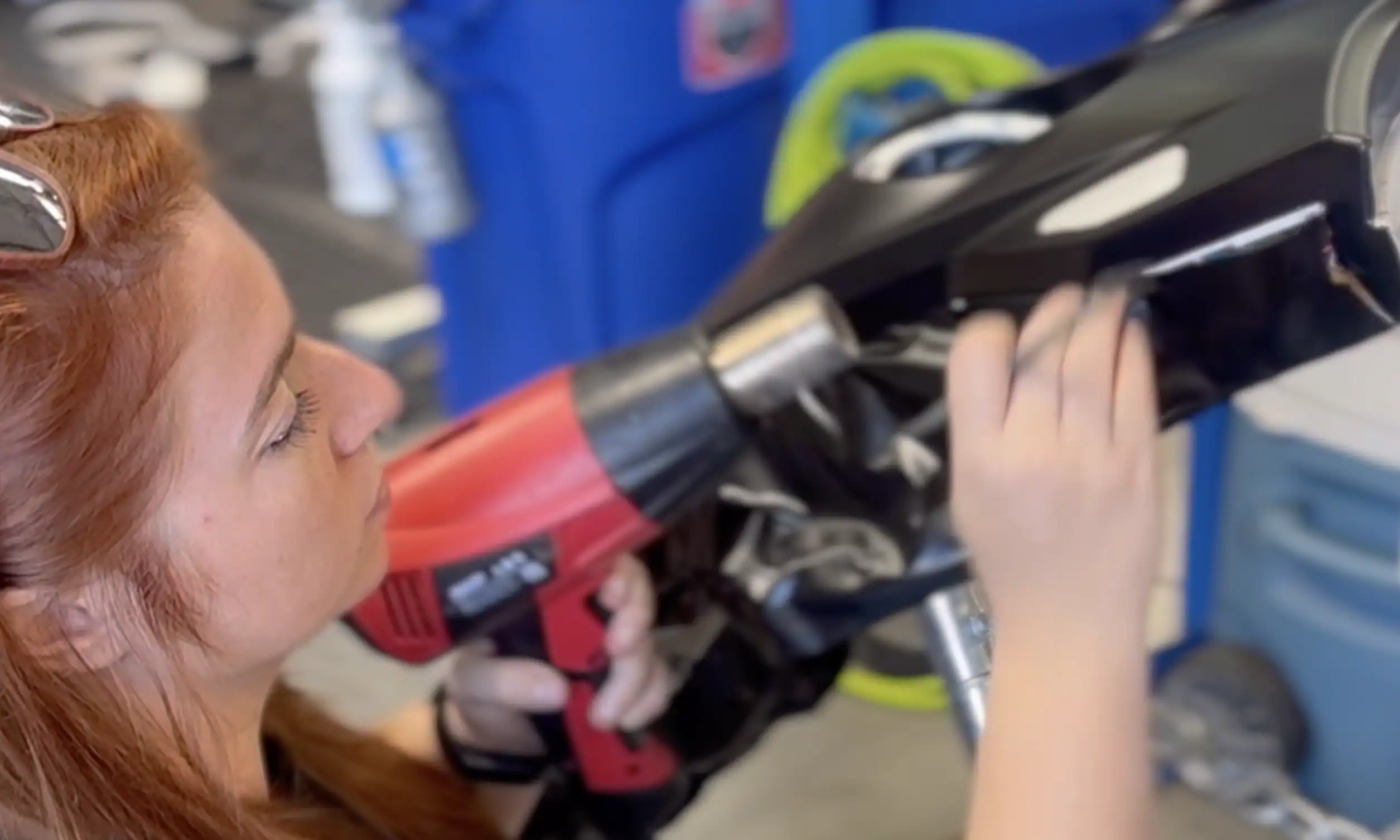 Technician using heat gun to install paint protection film with precision on vehicle panel
