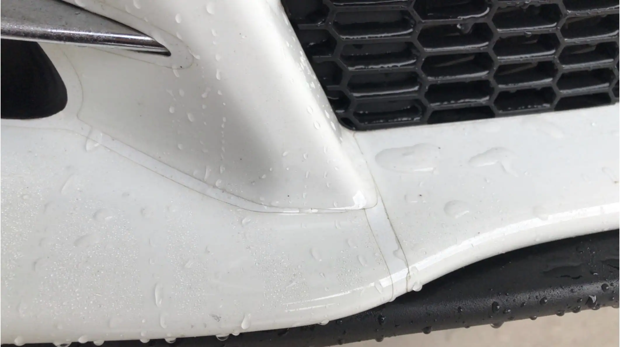 Visible seam in paint protection film on front bumper with dirt buildup along edge due to poor installation
