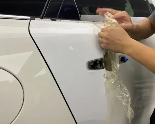 Removing yellowing paint protection film from a white car showing discoloration caused by sun exposure in Arizona