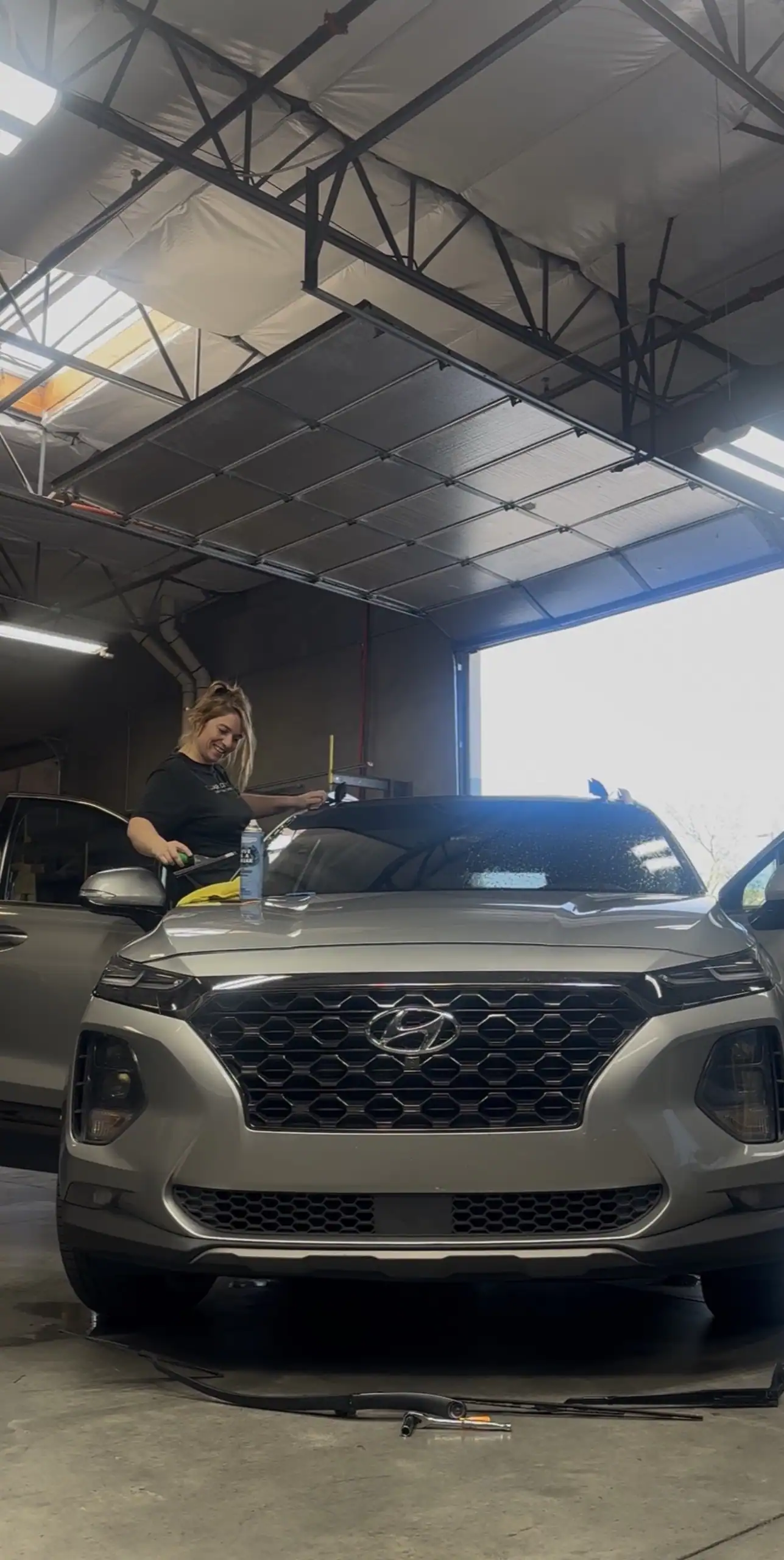 Professional Automotive Window Tint Installation Window tint technician performing a professional automotive window tint installation inside a climate-controlled facility.