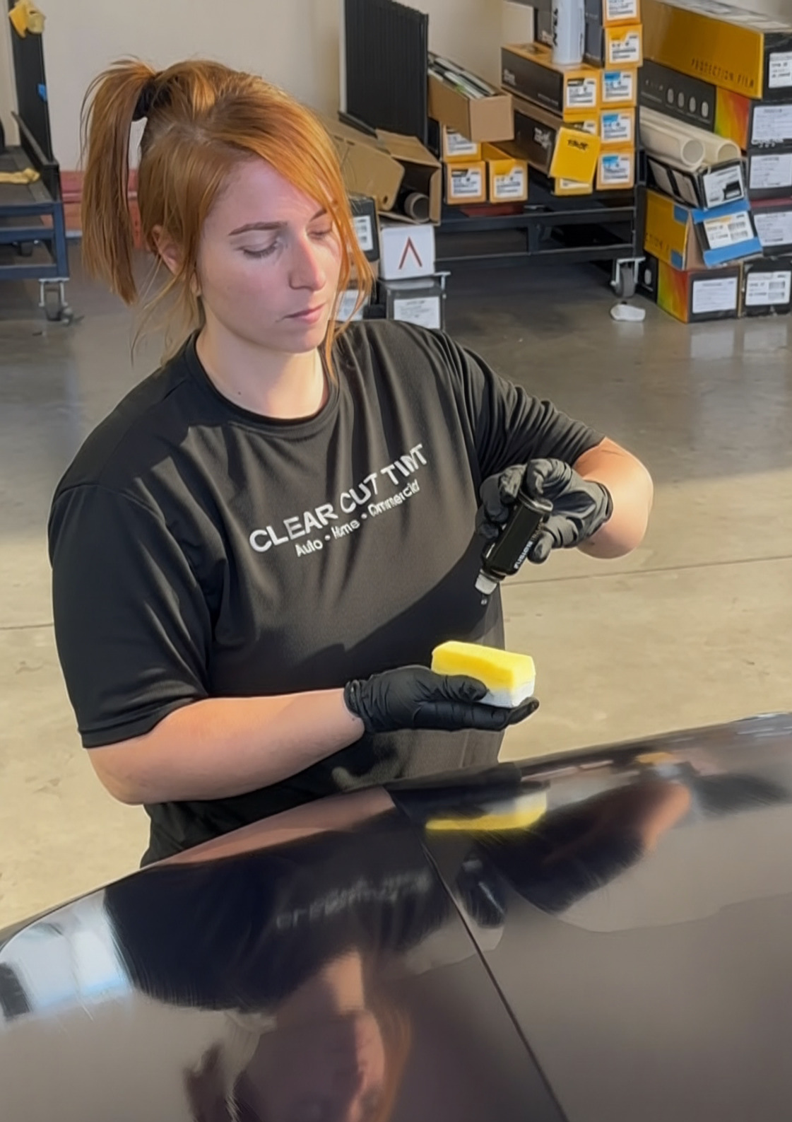 Certified technician at Clear Cut Glass & Tint applying ceramic coating to a vehicle at our Glendale shop, serving drivers throughout the Phoenix West Valley.