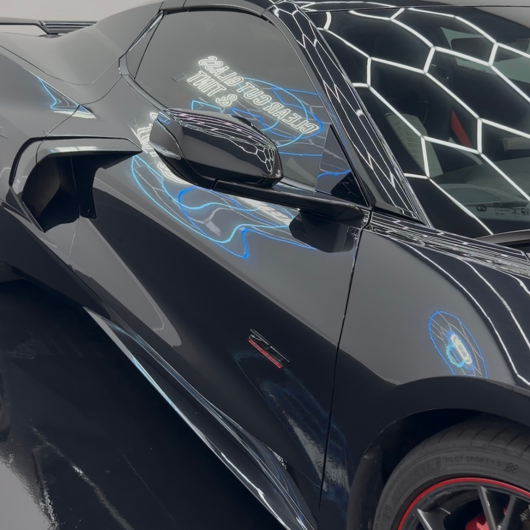 Black Corvette | XPEL Ceramic Coating Mirror Finish Black Chevrolet Corvette with mirror-like reflections across its glossy side panels after XPEL ceramic coating.